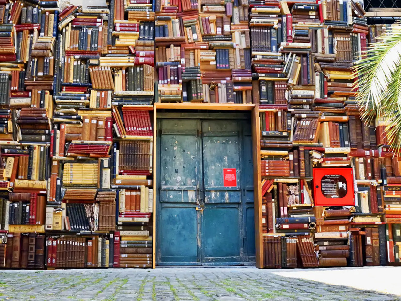 La biblioteca al aire libre que llena de magia las paredes del patio de un museo italiano pared de libros