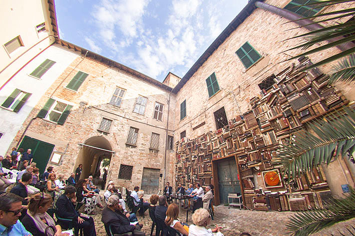 La biblioteca al aire libre que llena de magia las paredes del patio de un museo italiano pared de libros