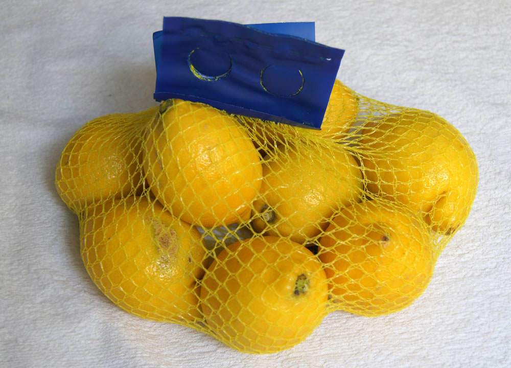 Limones envueltos en una red, similar a lo que sucede con las naranjas. 