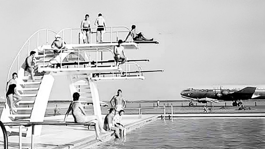 Bañistas en la pileta de Aeroparque, con un avión de fondo. 