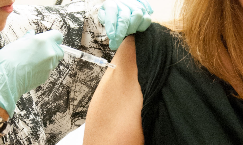 médica aplicando vacuna a mujer