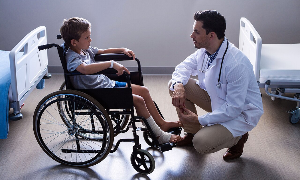 pediatra médico atendiendo niño en silla de ruedas