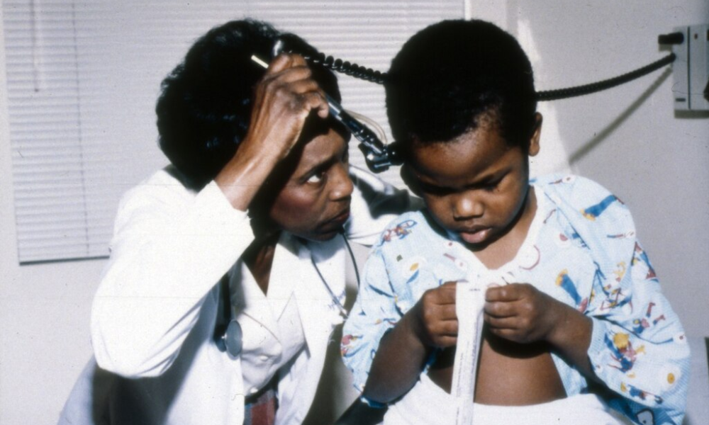 pediatra médica atendiendo niño pequeño