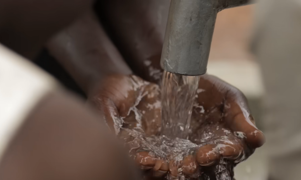manos de niño africano que toma agua.