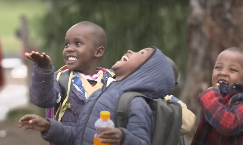 niños africanos contentos y sonriendo por la lluvia.