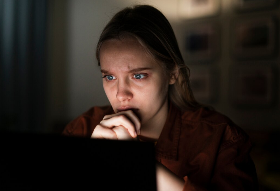 adolescente mirando la computadora el ordenador preocupada con cara de miedo por el grooming