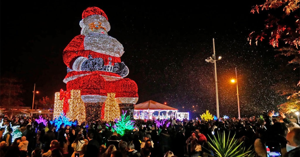 Personas visitando al Papá Noel más grande del mundo. 