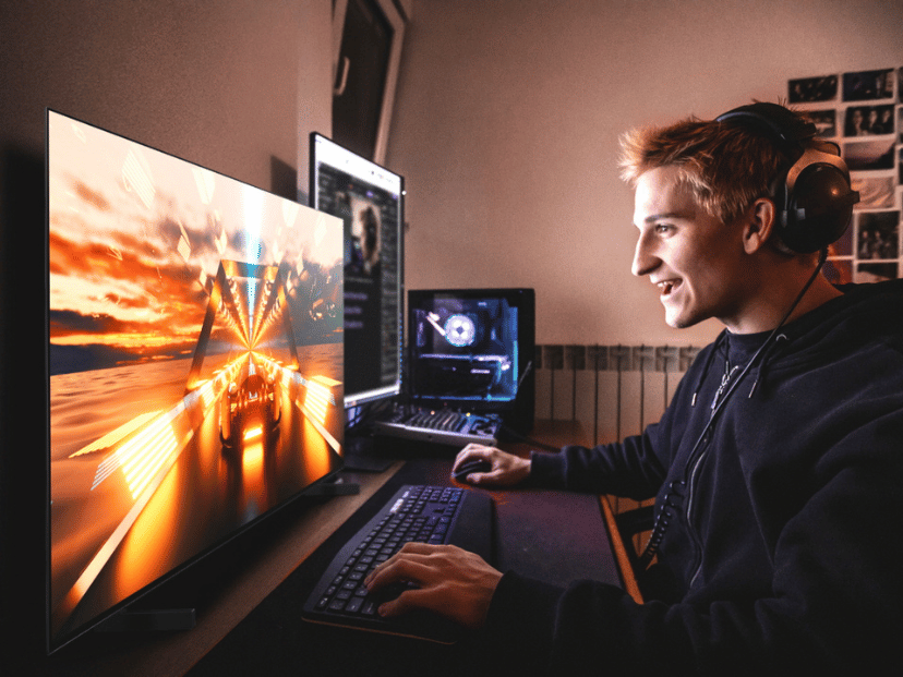 hombre joven varón jugando videojuegos en una computadora con auriculares