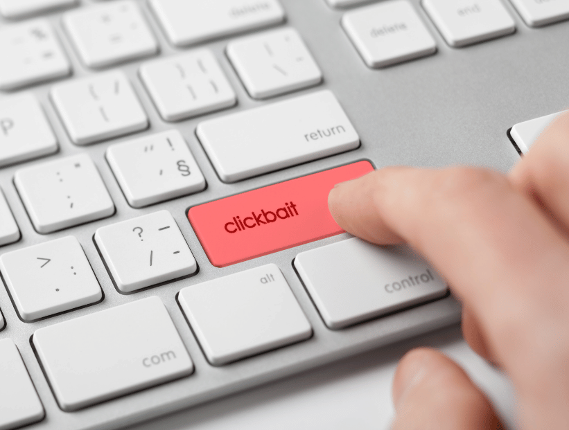 un teclado de computadora y un boton rojo que dice clickbait y persona presionandolo