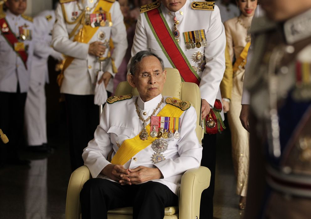 Rey Bhumibol Adulyadej de Tailandia sentado en una silla con su gabinete equipo detrás.