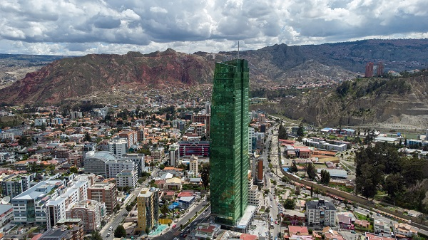 el edificio más alto de bolivia. rascacielos verde con montyañas sierras atrás.