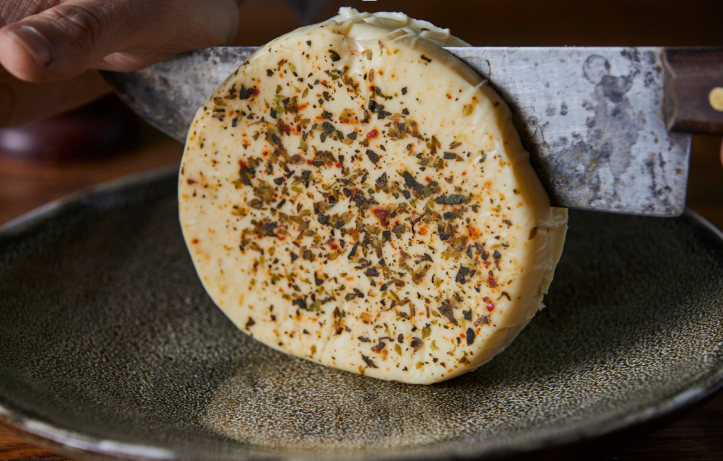 provoleta argentina con queso provolone especiado. siendo cortado en rodajas