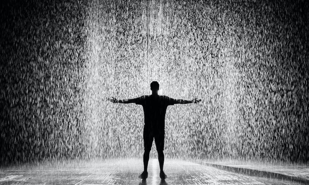 Hombre bajo lluvia de diciembre en la ciudad de Buenos Aires. 