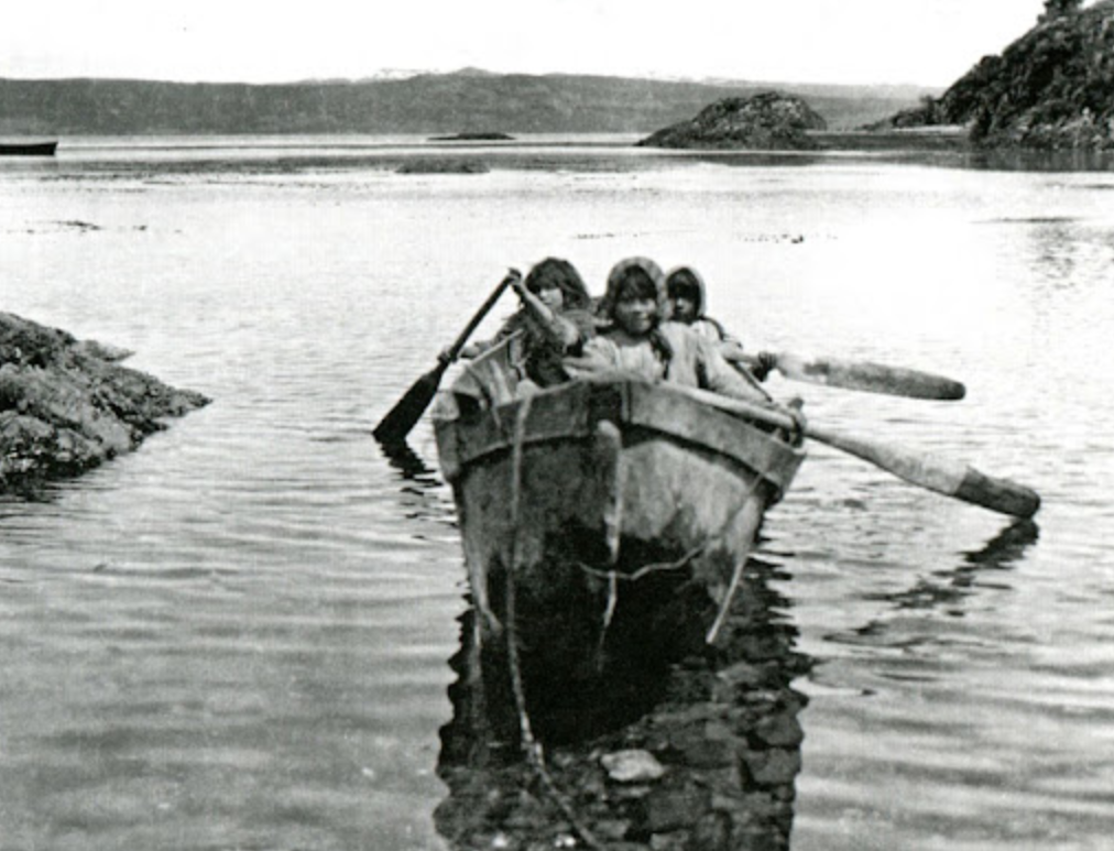 niños yamana en una canoa en el río abrigados