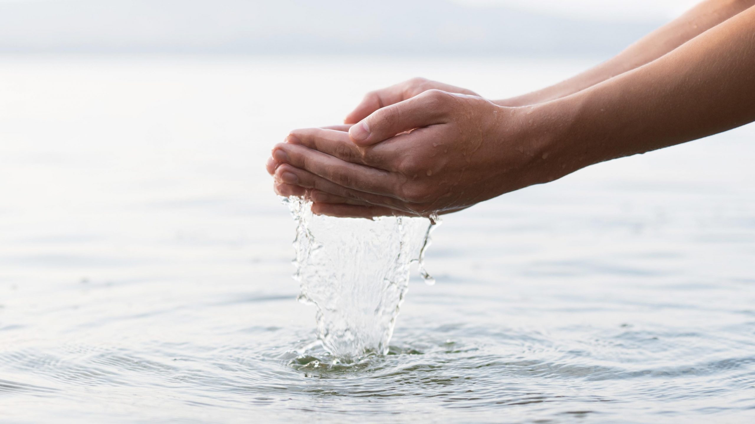 manos agarrando agua de mar