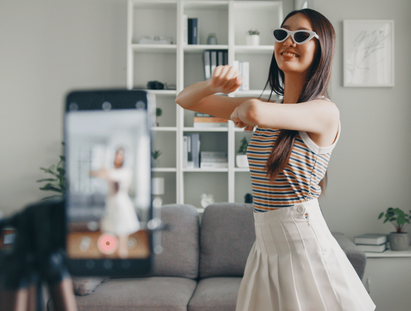 mujer con pollera y remera sobre fondo blanco bailando un baile de tiktok coreo viral