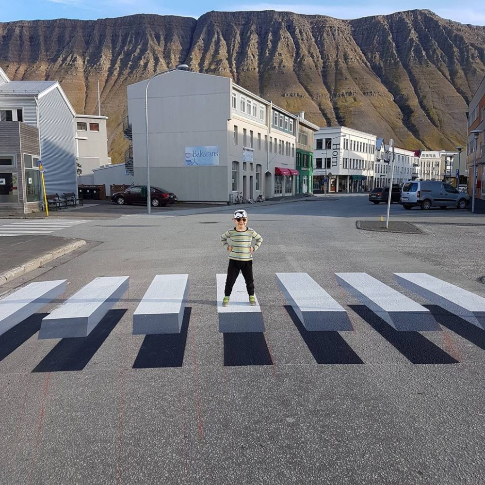 Un niño se para sobre la senda peatonal en 3D de Islandia. 