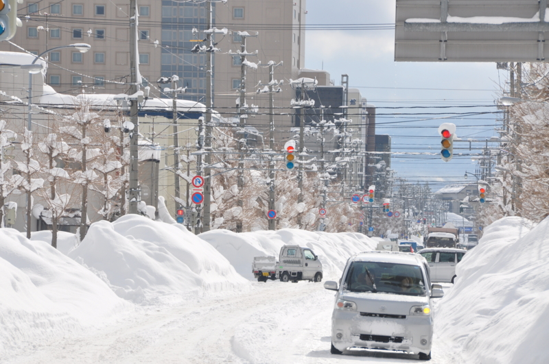 Personas conducen sobre la nieve en Aomori. 
