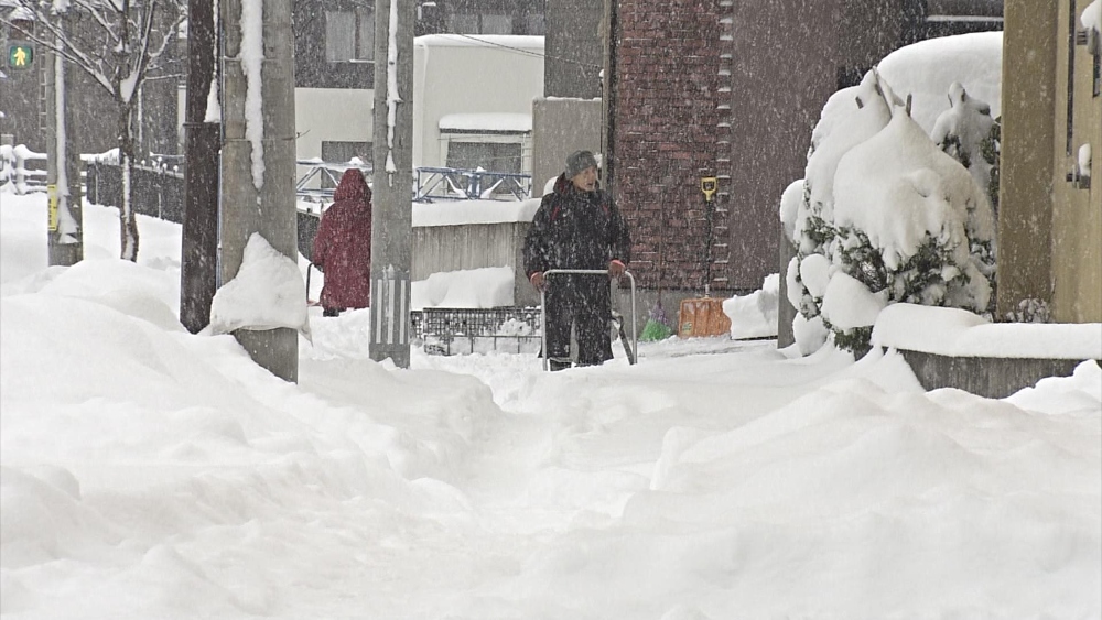 Una persona intenta caminar sobre la nieve en Aomori. 