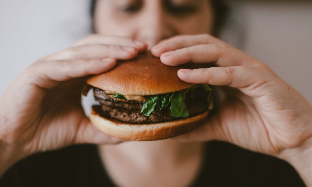 Persona disfruta en el Día Internacional de la Hamburguesa.