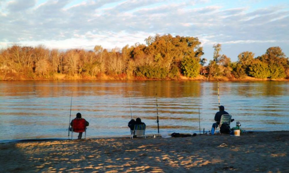 hombres pescando en el río uruguay.