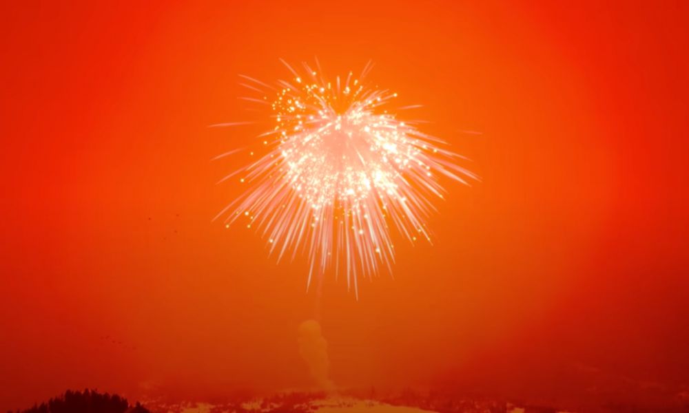 el fuego artificial más grande del mundo sobre un cielo rojo.