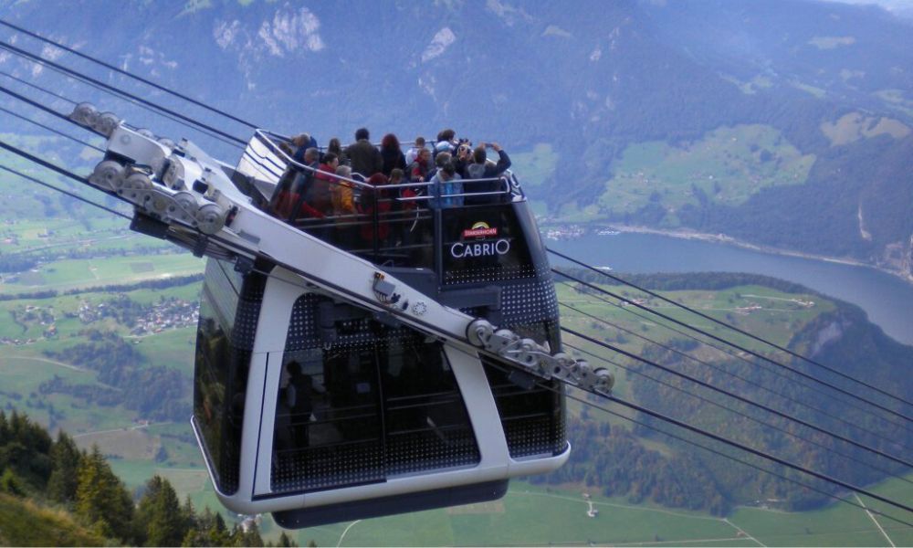 Personas disfrutan de su viaje en el primer teleférico descapotable del mundo. 