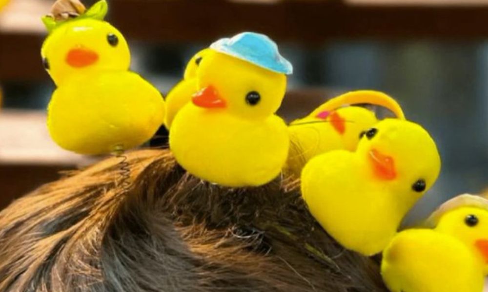 varios patitos de goma encima de una cabeza como accesorio moda