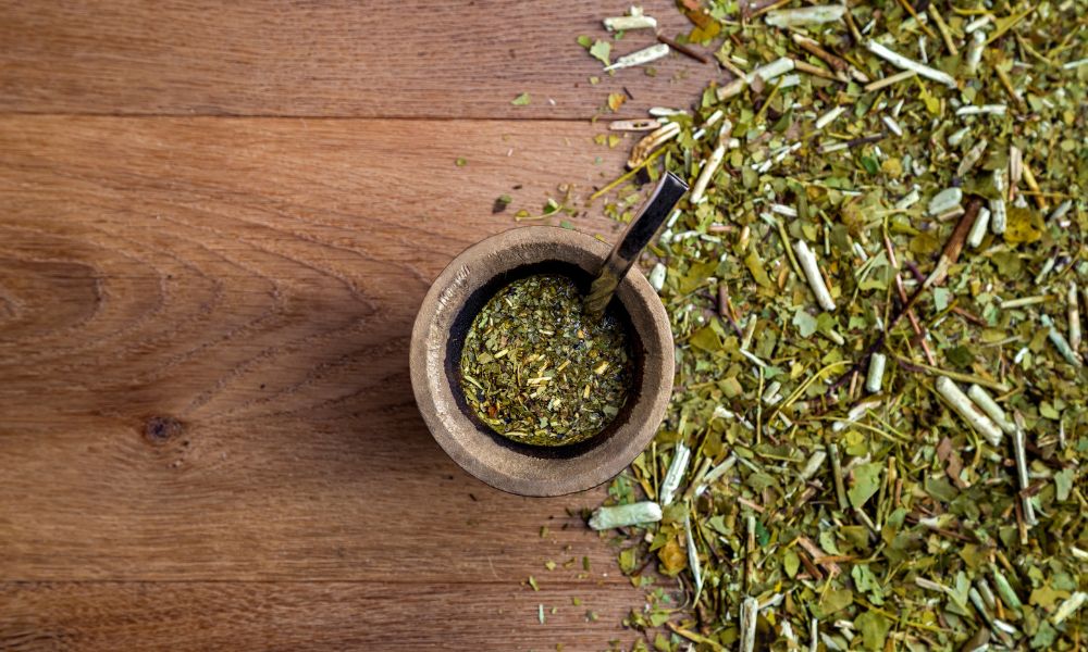 mate y mucha yerba tirada en la mesa