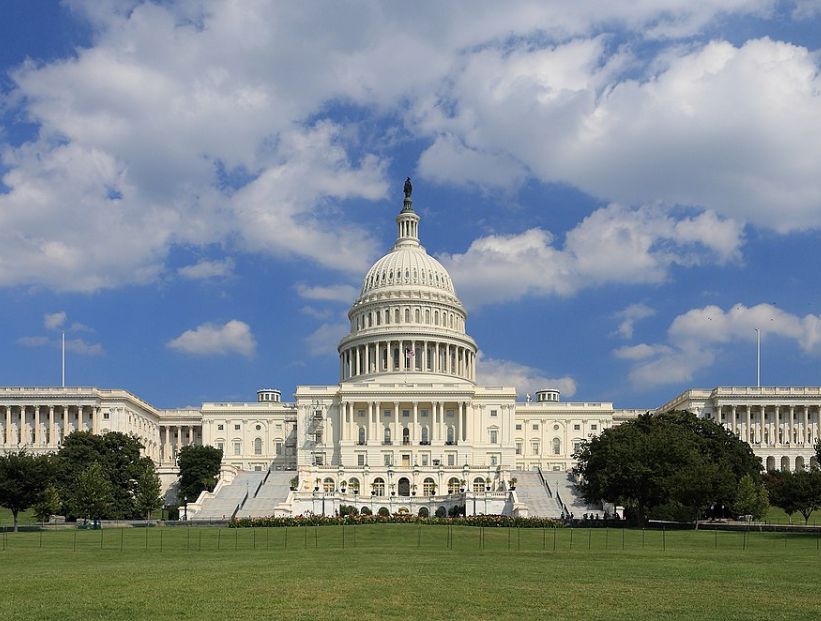 capitolio en washington d.c. con cielo con algunas nubes y pasto verde