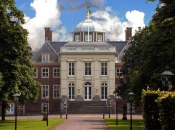 palacio huis ten bosch, donde vive la familia real holandesa, rodeada de árboles verdes