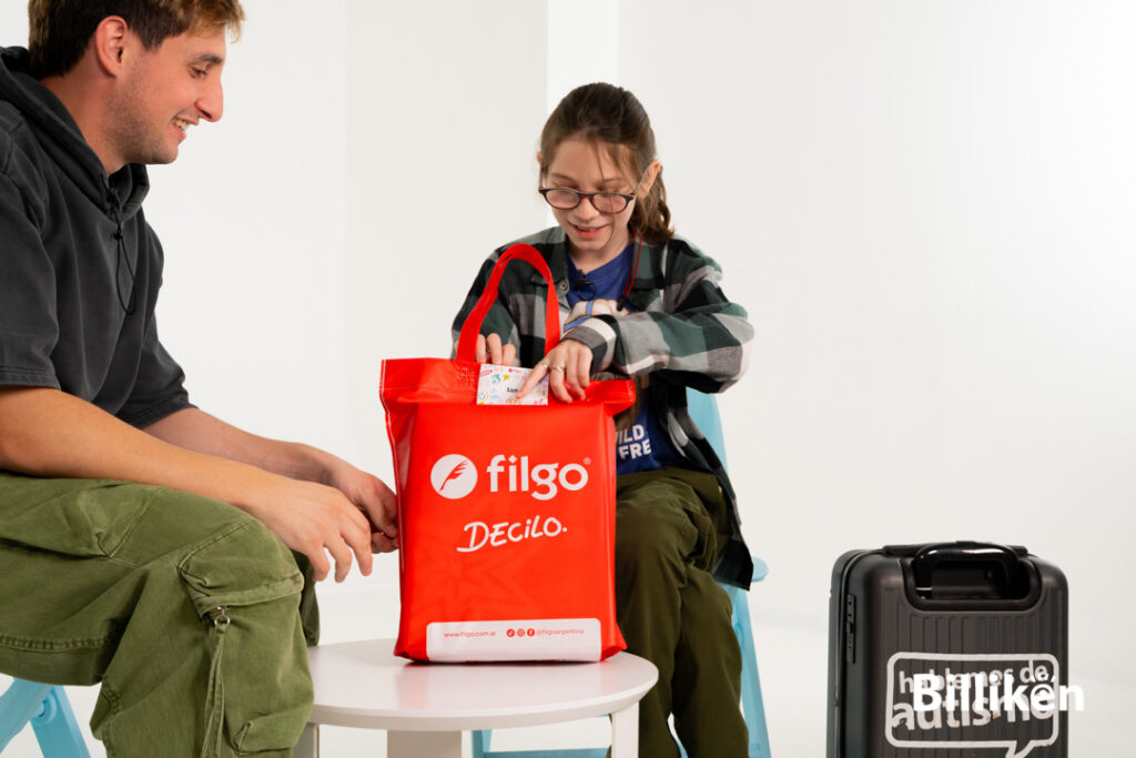 Ian Moche mirando con una sonrisa un regalo en una bolsa roja