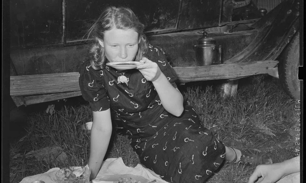 Mujer tomando café del plato que acompaña a la taza