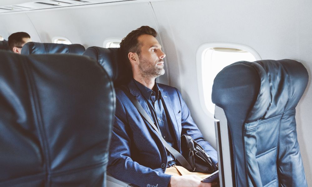 hombre sentado en un avión del lado de la ventana