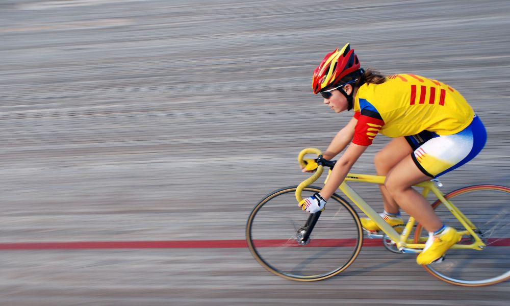 ciclista con outfit amarillo y casco rojo mujer