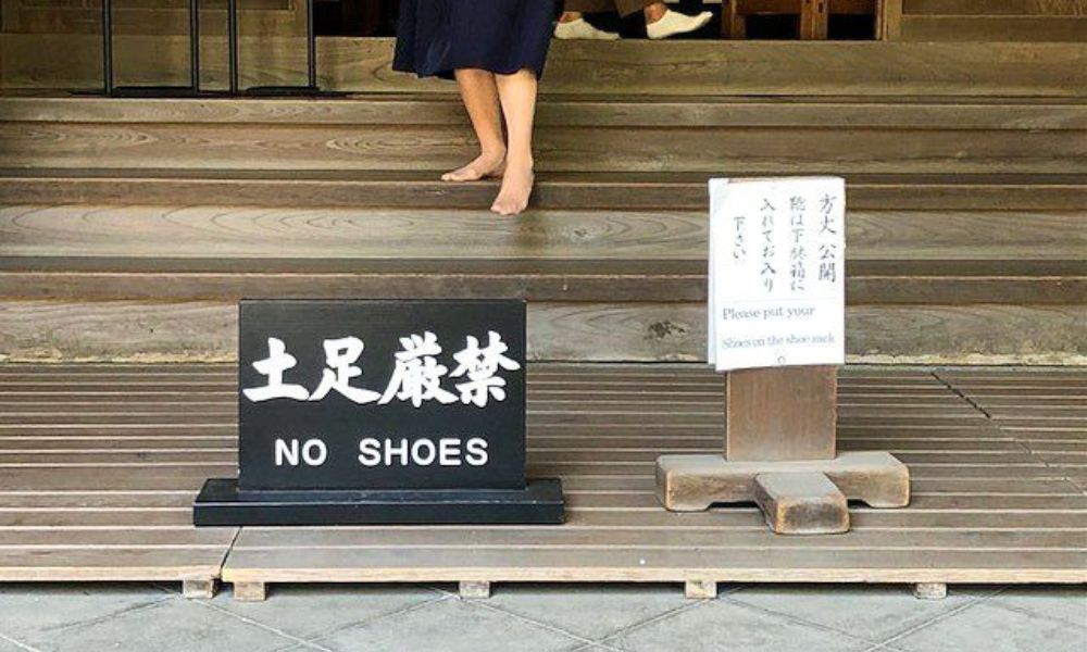 Cartel bien clarito: "no shoes", es decir, "prohibidos los zapatos".