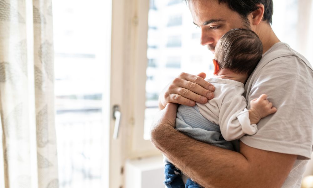 un papá sosteniendo a su bebé recién nacido