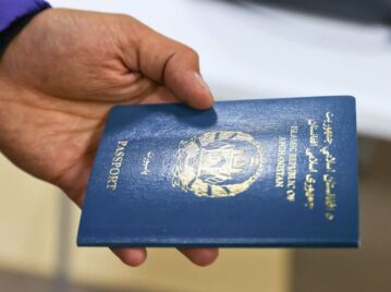 pasaporte menos poderoso del mundo, más débil: el de afganistán. mano de hombre sosteniendo pasaporte azul de afganistán.