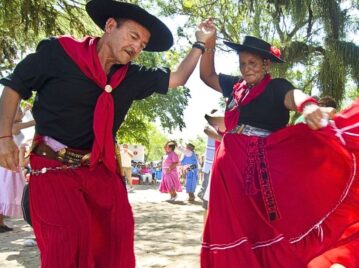 un señor y una señora bailan el chamamé vestidos con ropa tradicional del baile