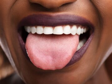 boca de mujer negra sacando la lengua y mostrando los dientes