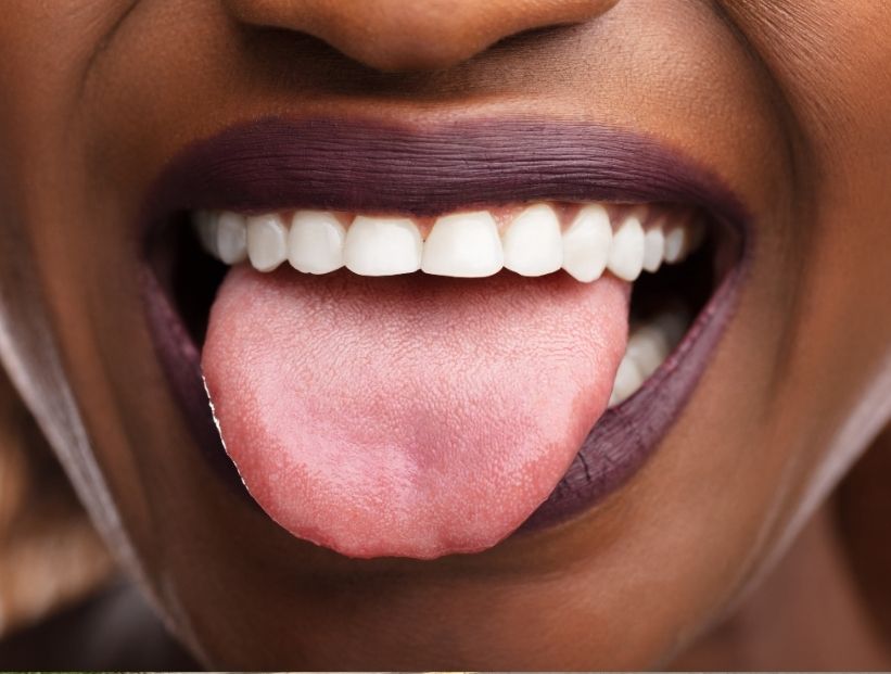 boca de mujer negra sacando la lengua y mostrando los dientes