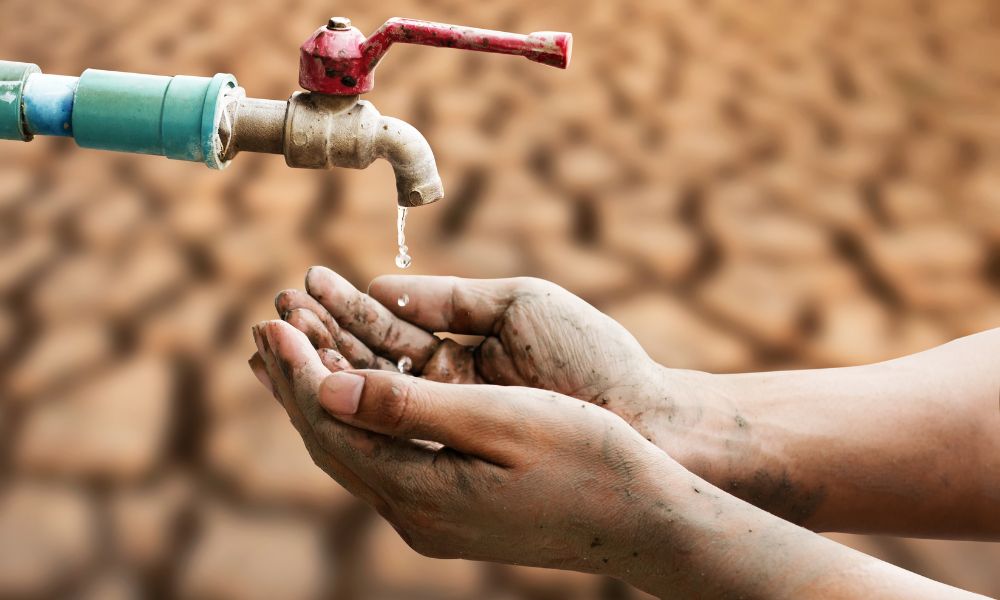 manos recibiendo poca agua de una canilla durante sequías