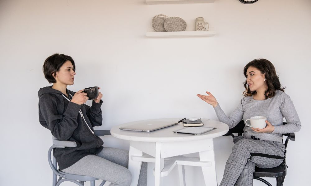 dos mujeres hablando mientras toman un café