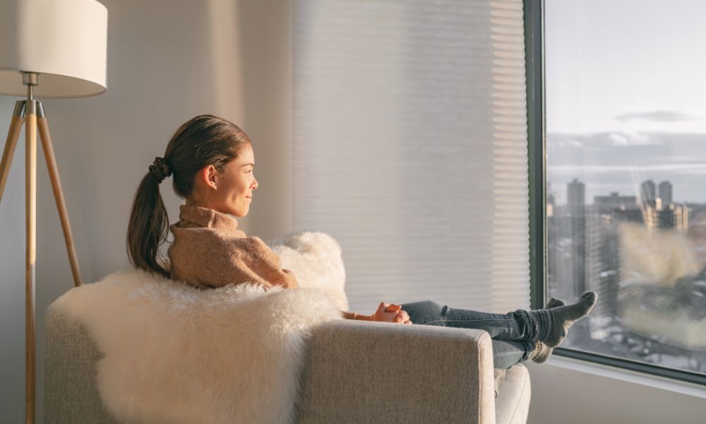 mujer en sillón mirando por la ventana