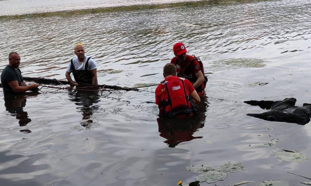 Grupo de buzos sacando la canoa antigua del río de Polonia