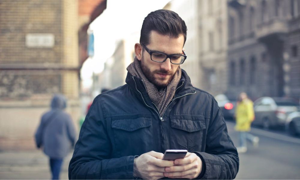 Hombre utiliza las redes sociales mientras camina. 