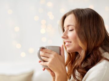 mujer tomando una taza de café en su casa practicando JOMO