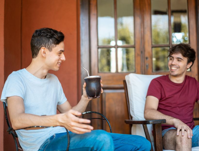 dos hombres argentinos hablando mientras toman mate