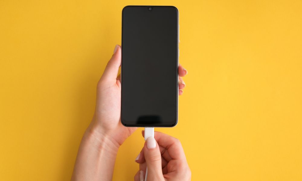 smartphone carga batería con fondo amarillo