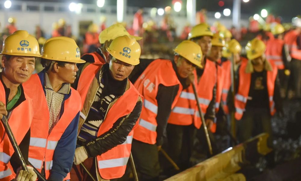 Algunos de los 1.500 trabajadores de China que construyeron la estación de tren Nanlong en tiempo récord.